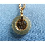 A small circular Jade Pendant, the centre set with cut out Old Chinese characters, suspended from