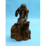 An Oriental Huangyang wood figure, depicting a man seated on rock with pipe, foot restored, 9in (