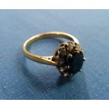 A sapphire and diamond Ring, the central oval facetted sapphire surrounded by ten small diamonds,