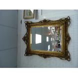 A 19thC ornately carved gilt wood framed bevel edge wall Mirror, 37in (95cm) x 41in (105cm)