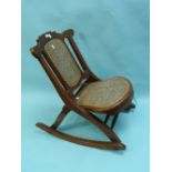 A 19thC mahogany folding Rocking Chair, with cane seat and back.