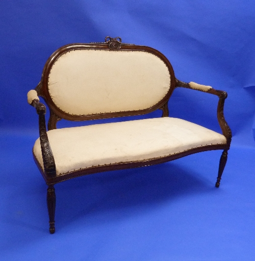 A French-style mahogany framed Love Seat, with serpentine front with decorative carvings, raised