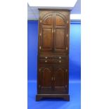 A George III built in oak Corner Cupboard, the top section with arched panelled doors enclosing