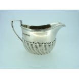 An Edwardian silver cream Jug, hallmarked Sheffield, 1904, of ovoid form with demi-fluted