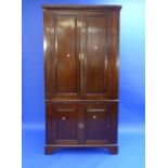 A George III mahogany Corner Cupboard, the dentil cornice above a pair of panelled doors enclosing