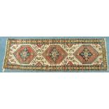 Tribal rugs; an Afghan runner with three central red, blue and yellow guls on a cream ground set