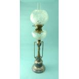 An Edwardian silver plated Oil Lamp, with ornate scrolled column, supporting corresponding cut glass