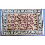 Tribal rugs; an Ispahan style rug, burgundy ground with sea-green border, the whole woven with