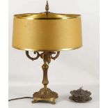 A brass and rococo style table lamp, tri-arm, cherub decoration, paw feet and a middle east white