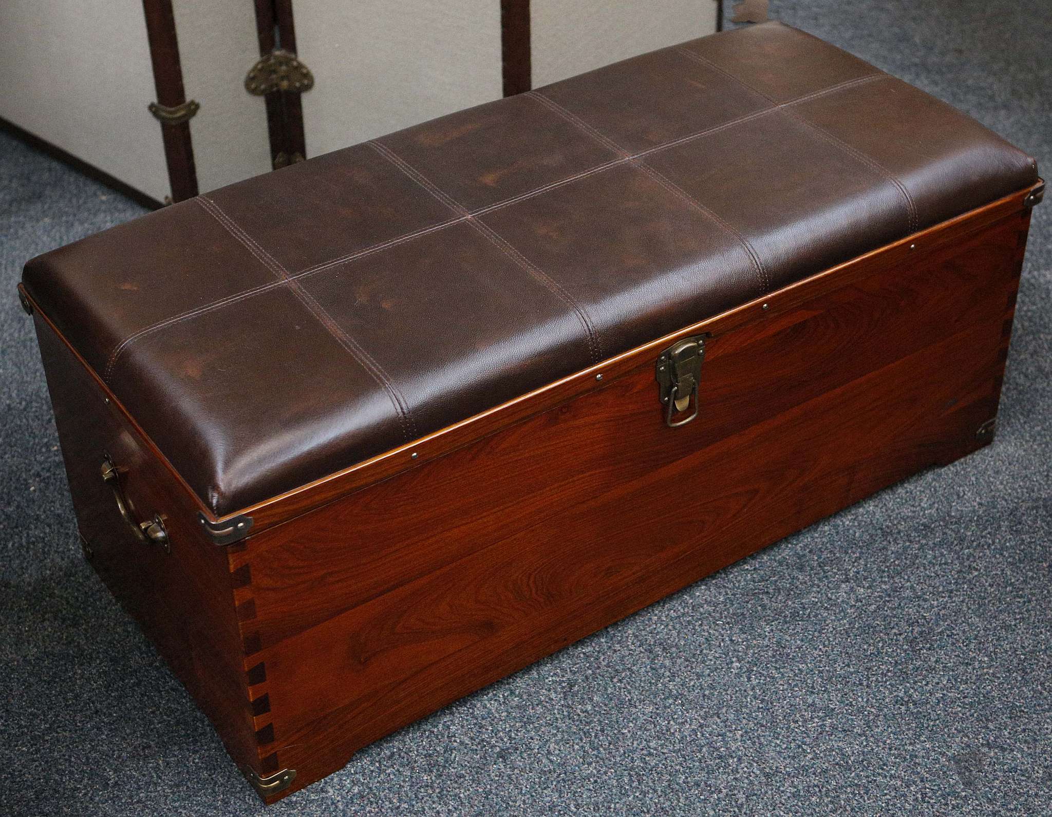 A Starbay ottoman with brown leather top, opening to reveal storage space and two heavy gauge