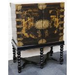 An 18th century chinoiserie black and gold lacquered two doored cabinet, opens to reveal many