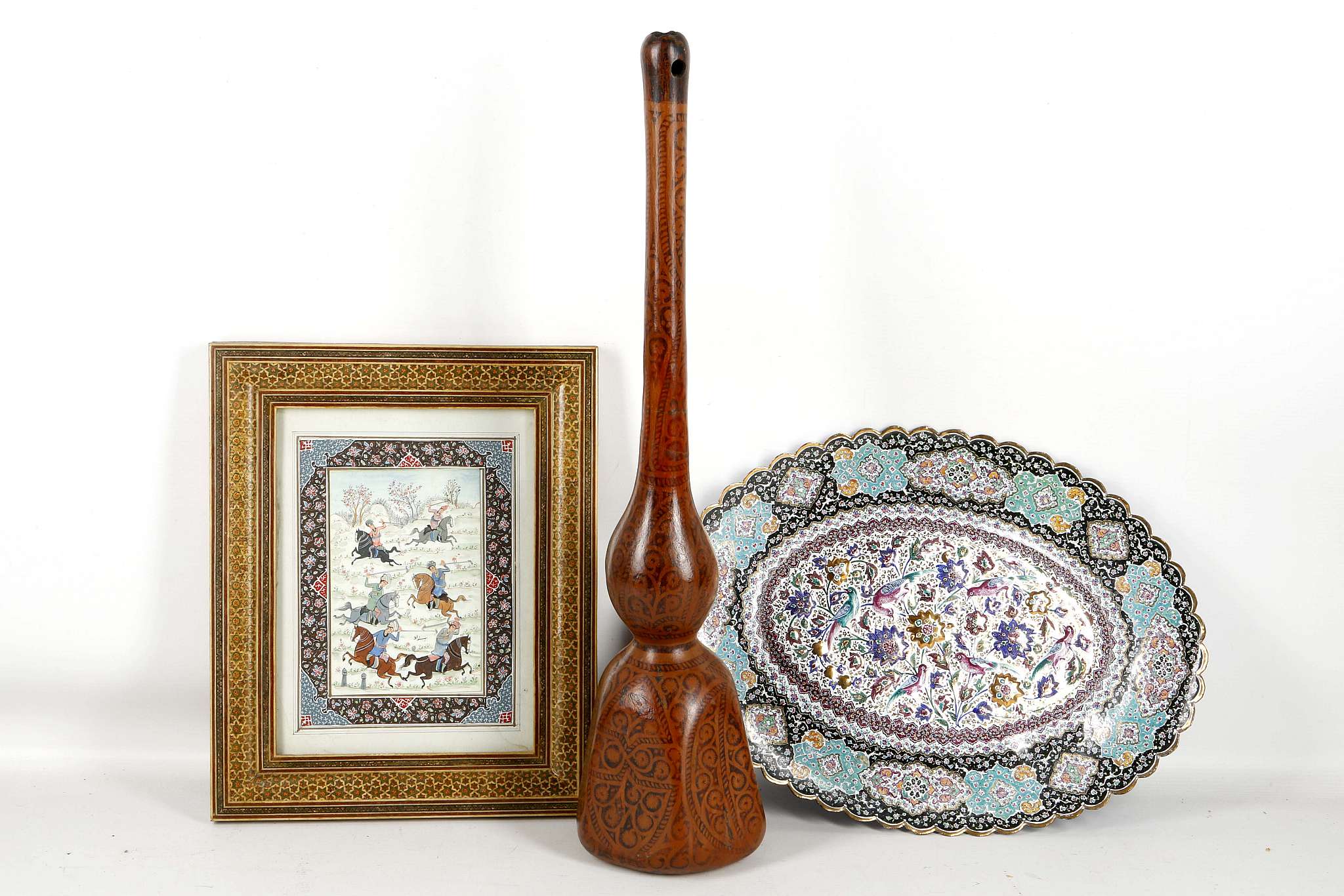 An oval Persian enamel tray, decorated with flowers amongst foliage, a mongrel miniature and a gourd