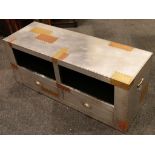 A riveted aluminium and copper patchwork television stand with two drawers and two storage openings,