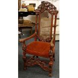 A mid 19th century elbow chair, carolean design, red finish, dolphin, urn and floral carved