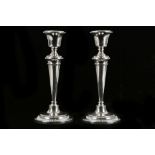 A pair of George V period, hallmarked silver table candlesticks, having baluster columns, raised