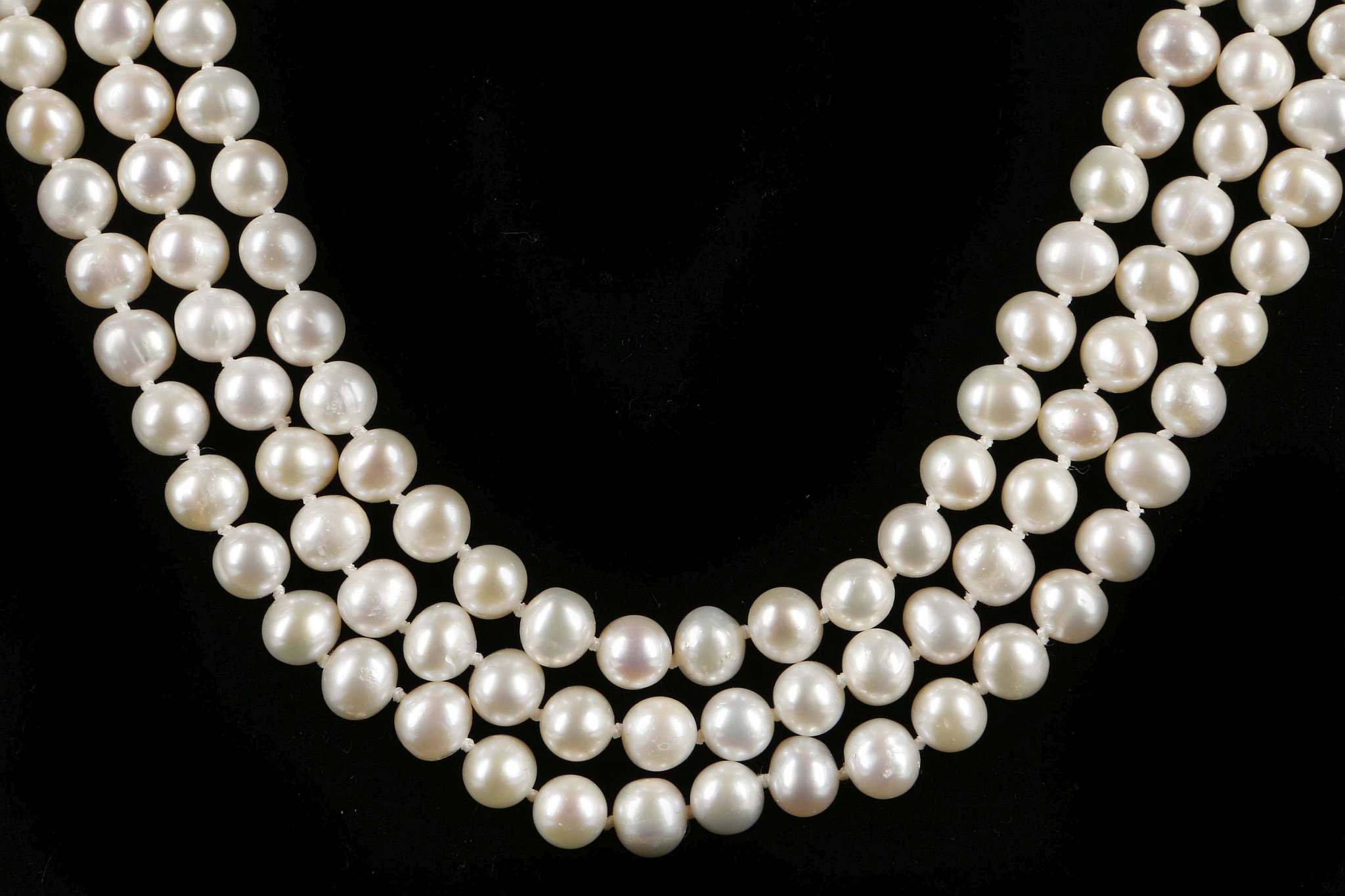 A three strand set of pearls with bar clasp.