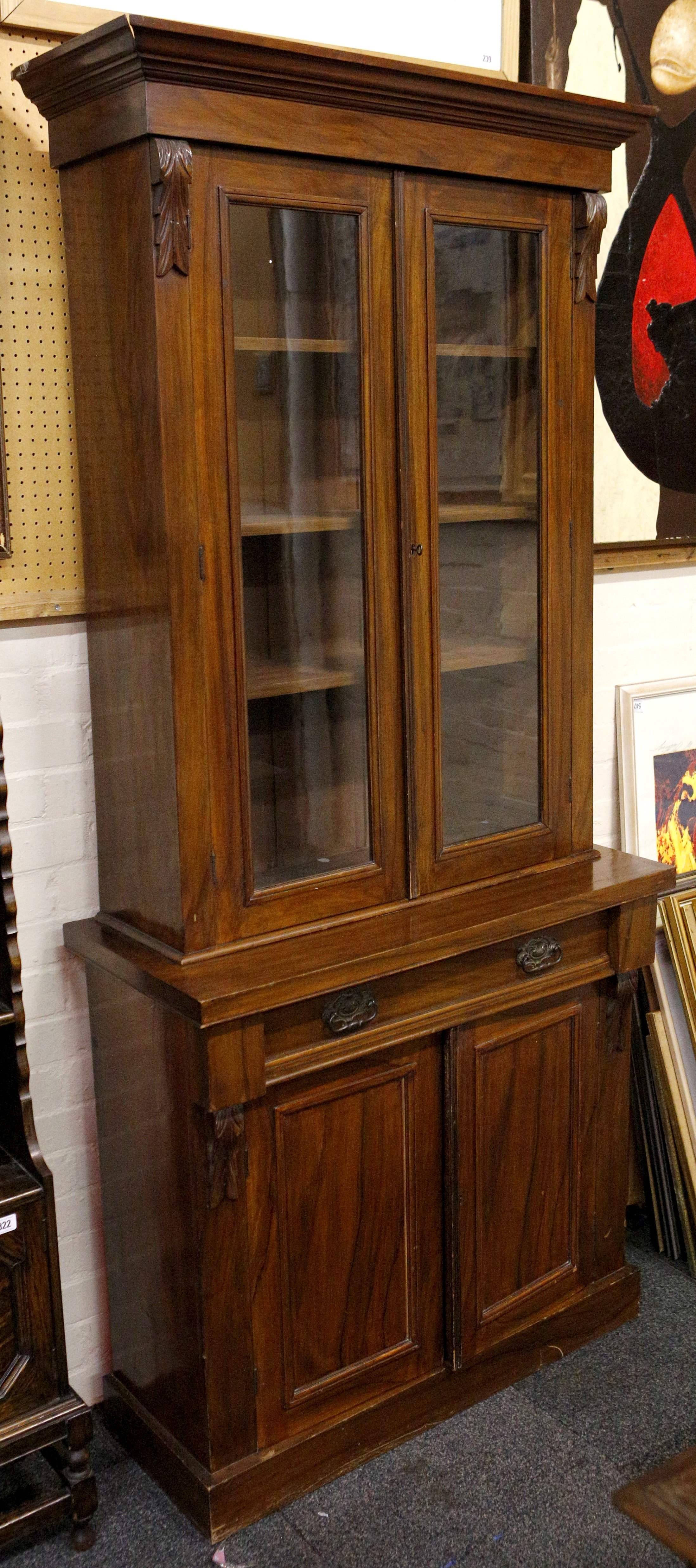 A Victorian mahogany glazed bookcase, on a base with a cushion frieze drawer over cupboards, on a