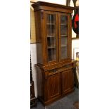 A Victorian mahogany glazed bookcase, on a base with a cushion frieze drawer over cupboards, on a