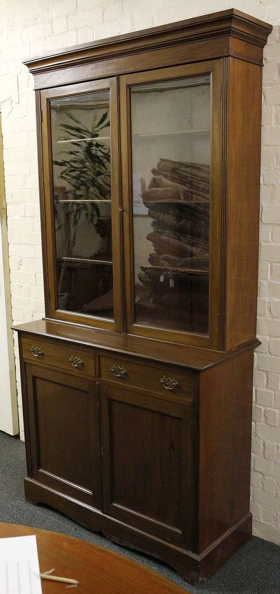 An early 20th century glazed book cupboard, mahogany, double doors over drawers and doors. 212cm