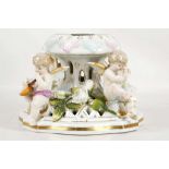 A Dresden porcelain centrepiece base or stand, 19th century, modelled with four winged cupids