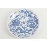 A Chinese blue and white dragon dish, the beasts encircling a flaming pearl among scrolling clouds