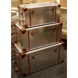 A set of three aluminium, graduated aviation chests with a leather and rivet trim, largest 80 x 45 x