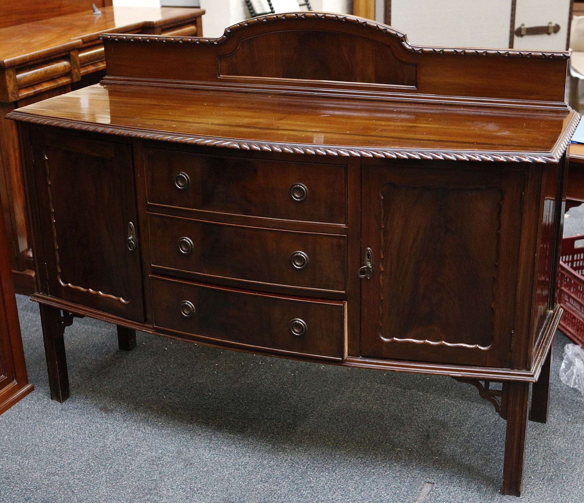 A 1930's bow front sideboard, mahogany, egg and dart bead to arch backboard, cupboards flanking 3