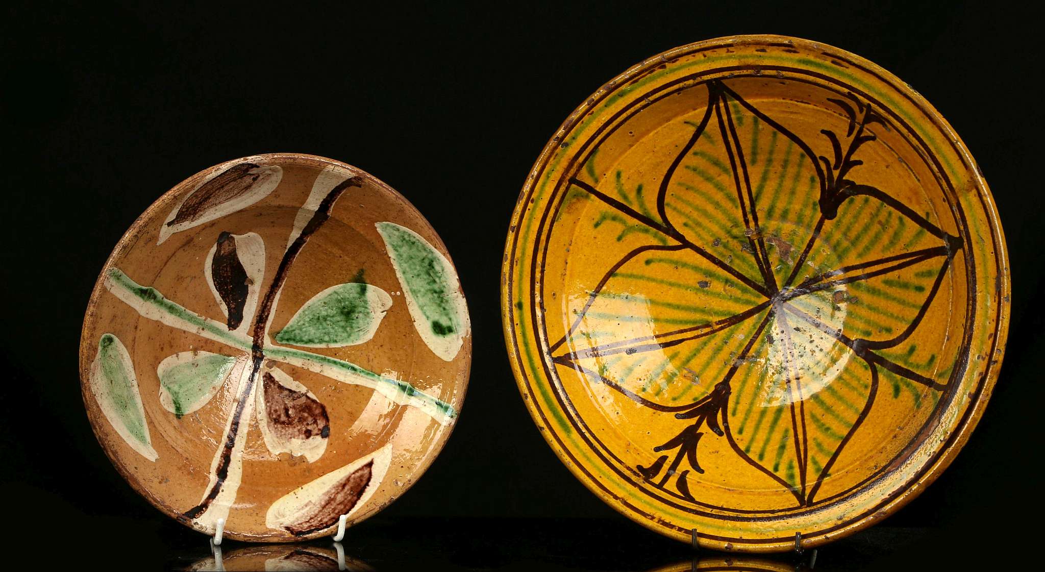 TWO SLIP-DECORATED PERSIAN POTTERY BOWLS, 19th century or earlier, one with stylised quatrefoil leaf