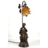 A bronzed Deco style figural table lamp with classical maiden seated with book, satin amber glass