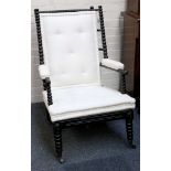 An early bobbin turned wing armchair, ebonised finish and Greek squab cushion.