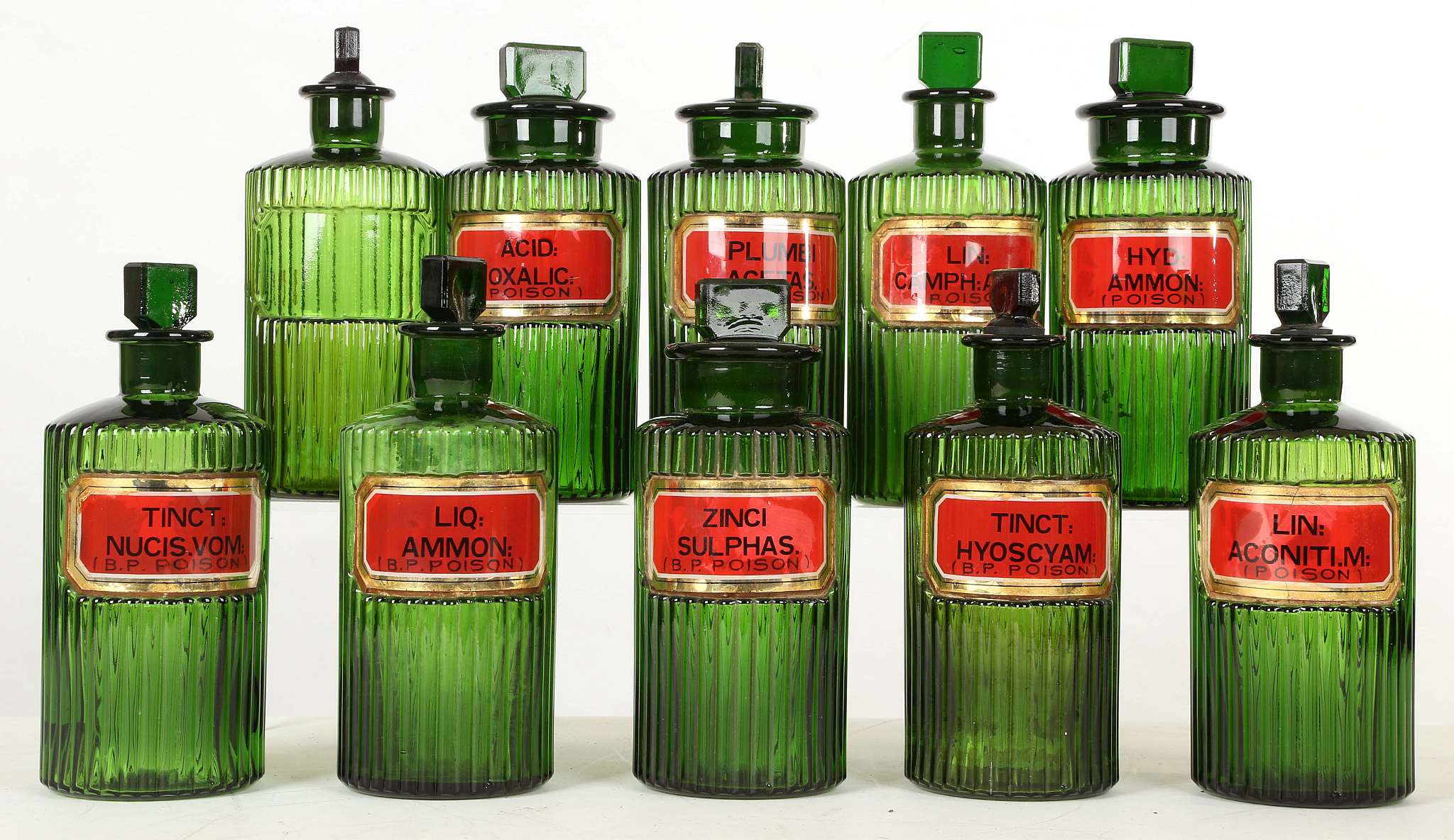 A SET OF TEN GREEN RIBBED GLASS APOTHECARY OR POISON BOTTLES AND STOPPERS, early 20th century,