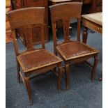 A set of four oak dining chairs in Arts & Crafts manner, supported on sabre legs (4)