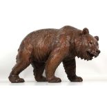 A c.1910 Black Forest carving of a strolling bear, 24cm high x 44cm long.