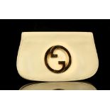 GUCCI CLUTCH BAG, 1980s, cream leather with large gilt metal logo to front flap, 28cm x 16cm