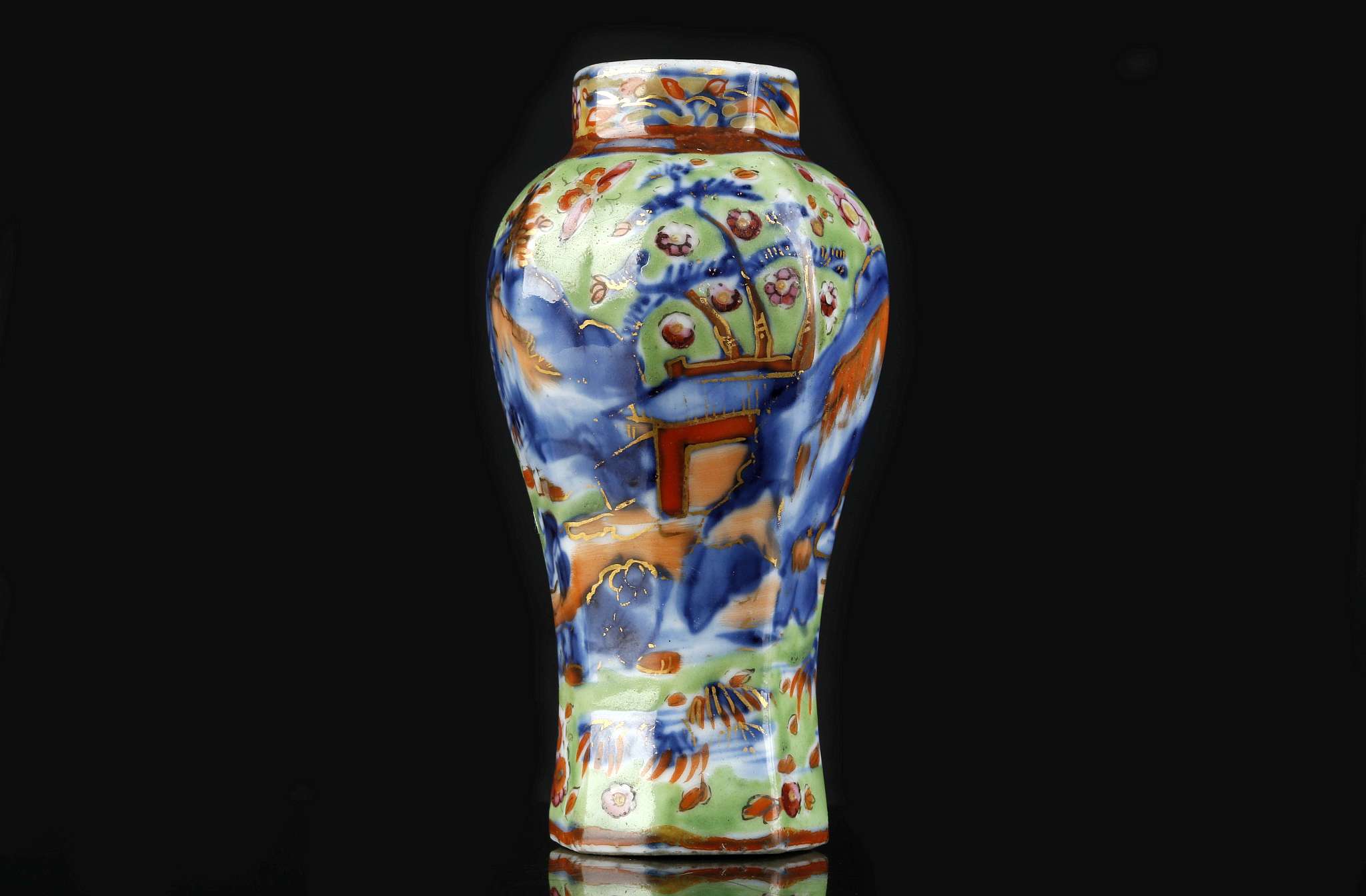 A CHINESE CLOBBERED MINIATURE BLUE AND WHITE VASE.
Qing Dynasty.
Of octagonal section, decorated