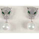 A pair of silver panther earrings set with green s