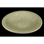 A CHINESE LONGQUAN CELADON CHARGER.
Ming Dynasty.
The interior moulded with ribs, the glaze is of