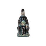 A CHINESE FAHUA STONEWARE MODEL OF A SEATED DIGNITARY.
Ming.
Modelled seated on a rocky base,