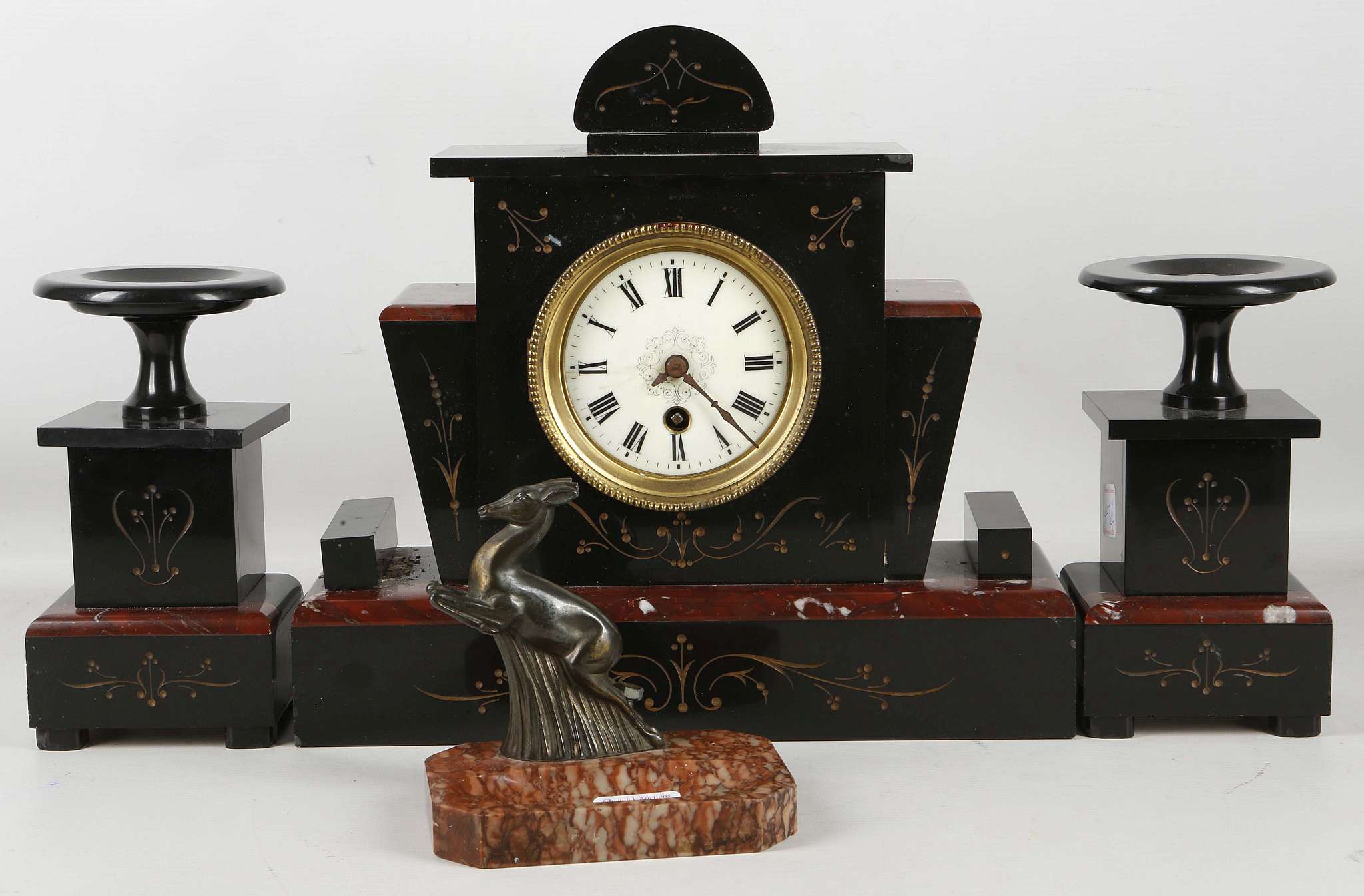 An Edwardian Belgian slate and red marble clock garniture, having a shaped clock case and matching