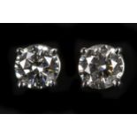 A 14k white gold pair of diamond stud earrings, to