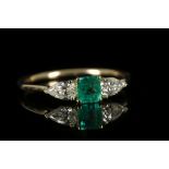 An 18ct gold, emerald and diamond set three stone