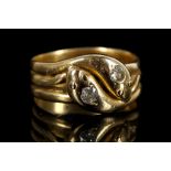 An 18ct yellow gold double snake ring, the heads set with small diamonds.