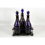 A set of three Bristol blue glass Georgian decanters, each titled with pseudo wine labels in gold,
