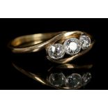 An antique 18ct yellow gold and diamond, three stone cross-over ring, the old cut stones set i