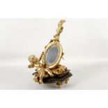 An Italian rococo style gilded bronze table glance mirror, in the form a mandolin upon a cushion