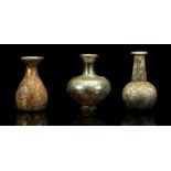THREE ROMAN GREEN GLASS VESSELS Circa 2nd-3rd Century A.D. Including a squat bodied flask on