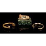 TWO WEST AFRICAN BRASS ALLOY BRACELETS Penannular with flaring terminals, 8cm and 8.5cm diam; AND