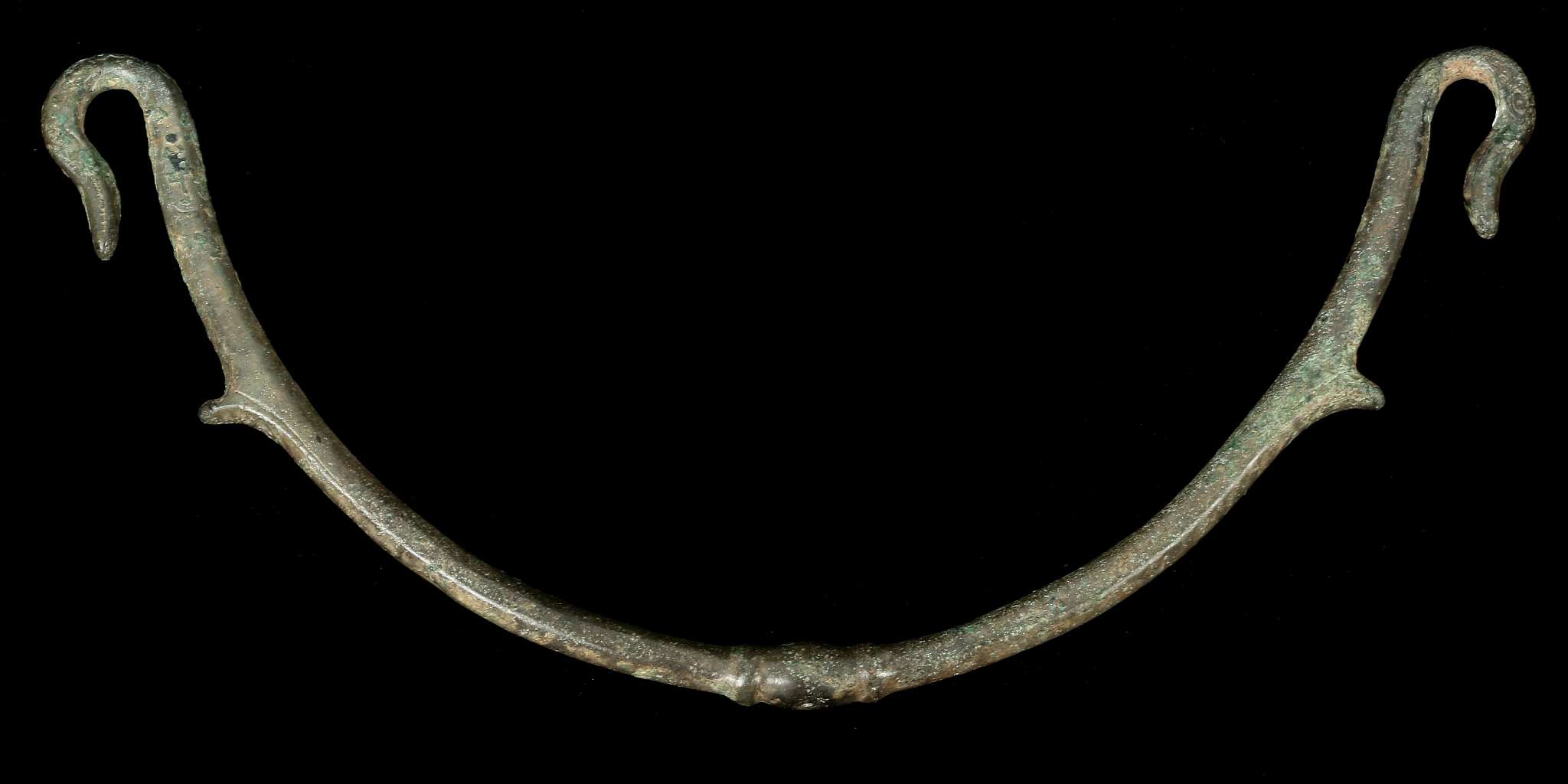 A ROMAN BRONZE VESSEL HANDLE Circa 2nd-3rd Century A.D. Of arching shape, the two hook terminals