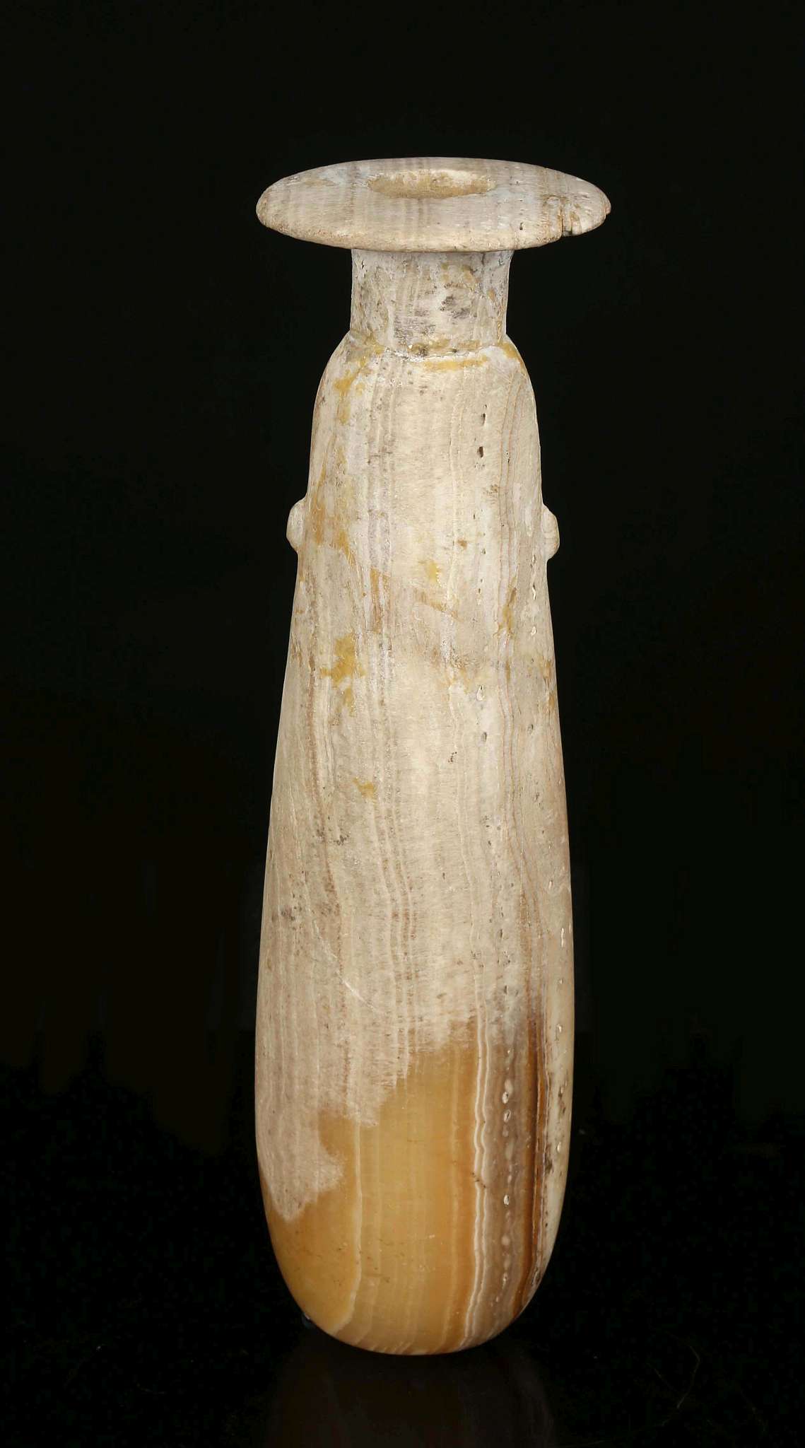 A GREEK ALABASTER ALABASTRON Circa 6th Century B.C. The elongated body tapering to the neck, with