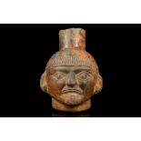 A MOCHE HEAD VESSEL, PERU Depicting the head of a man, possibly a priest, with a short fringe over